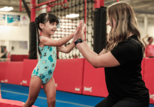 Gold Medal Coach and Gymnast High Fiving