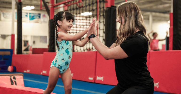 Gold Medal Coach and Gymnast High Fiving